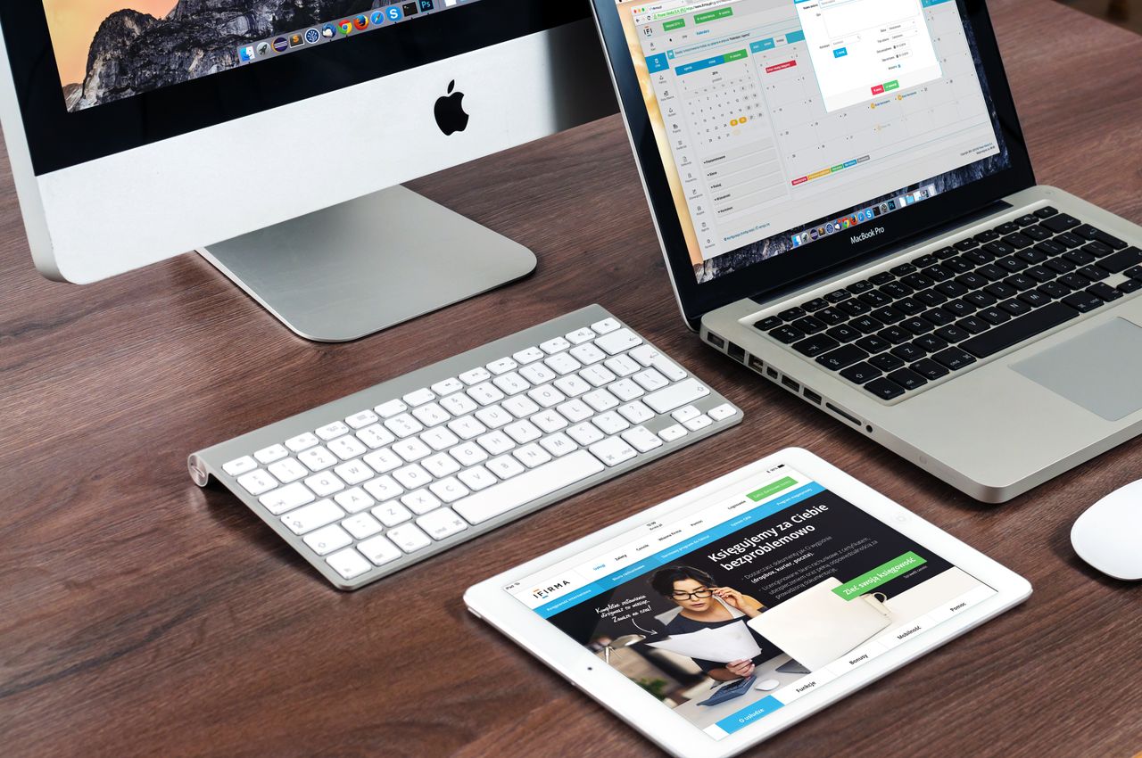 services-img A sleek office desk setup featuring Apple devices: iMac, MacBook, and iPad.